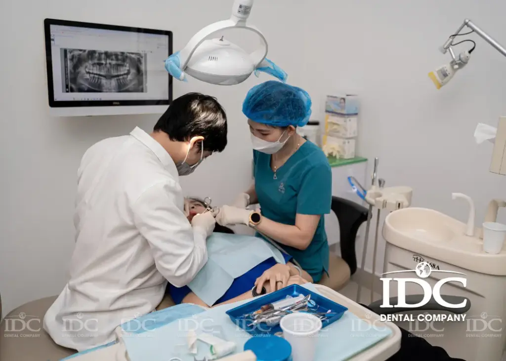 Dr. Ho Hoang Anh is treating a patient at IDC Dental Clinic.